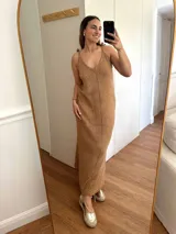 Vestido largo tejido con hilo de algodón y lurex color verde oliva. Silueta trapecio, escote en V, tiras regulables con borlas, espalda abierta y tajos laterales.