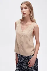 Blusa color beige de poliéster, al cuerpo y con cuello en V.