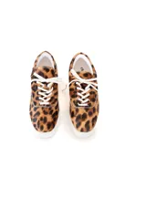 Zapatillas bajas con estampado animal print de leopardo, cordones blancos y suela blanca.