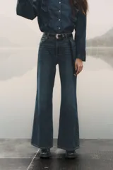 Pantalón de jean azul de corte acampanado, con tiro medio y cinco bolsillos.