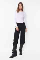 Campera puffer negra de cuero sintético, con cuello alto, cierre frontal con cremallera y bolsillos laterales.