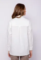Camisa blanca de manga larga con jareta para fruncir en la cintura y cierre frontal de botones.