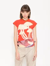 Musculosa roja de algodón pima orgánico, de calce al cuerpo, escote redondo y mangas ranglan. Lleva estampa de hongos en el delantero y detalle de tela estampada en la cintura.