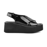 Sandalias negras de charol con plataforma y tiras cruzadas.
