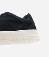 Championes de cuero ante color azul marino, de estilo urbano, con caña corta, cierre con cordones, puntera redondeada y suela blanca.