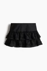 Minifalda negra con bordado floral y volantes escalonados.