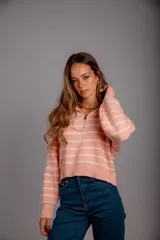 Sweater de punto color beige con rayas horizontales blancas, cuello polo con cierre de cremallera y mangas largas.