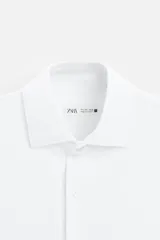 Camisa azul marino slim fit de manga larga con cuello italiano abierto y cierre frontal con botones.