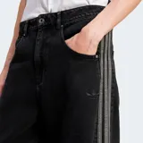 Pantalón de jean negro de corte ancho con tres tiras plateadas a los costados y logo de Adidas bordado en el muslo.