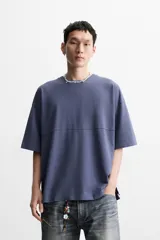 Camiseta azul de corte holgado, cuello redondo y manga corta. Tiene un efecto lavado que le da una apariencia única.