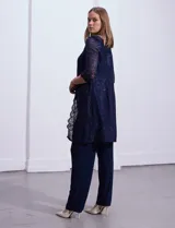 Conjunto de pantalón, blusa y chaqueta de encaje azul marino, marca RM Richards. La blusa es de encaje con escote redondo. El pantalón es de seda fría con cintura elastizada. La chaqueta es de encaje con mangas 3/4.