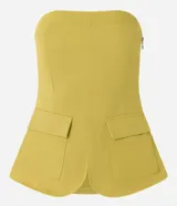 Blusa sin breteles color amarillo mostaza, confeccionada en sarga, con cierre por cremallera invisible en el lateral y bolsillos con solapa en la parte del frente. Posee lastex en la espalda y bajo redondeado.