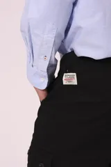 Pantalón cargo color beige con bolsillos laterales con solapa y cierre de botón a presión.