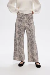 Pantalón jean ancho con estampado de piel de serpiente en tonos beige y gris.