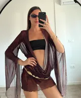 Vestido corto marrón traslúcido con escote en V profundo, mangas largas acampanadas y cinturón dorado.