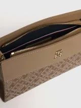 Cartera cruzada Tommy Hilfiger color beige con monograma TH en jacquard. Tiene correa ajustable y logo metálico TH en el frente.