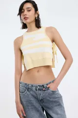 Top corto amarillo con rayas horizontales blancas, cuello redondo y tiras laterales para atar.