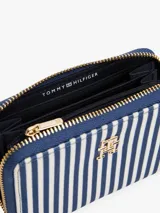 Billetera Tommy Hilfiger con diseño de rayas verticales azules y blancas, cierre de cremallera, múltiples ranuras interiores para tarjetas, dos compartimentos principales y un compartimento interior con cremallera.