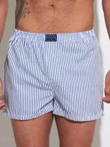 Bóxer de algodón blanco con estampado de flores pequeñas color celeste, con cintura elástica y logo de la marca en el centro.