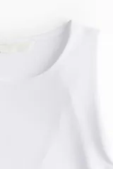 Body blanco de punto elástico suave, con escote redondo, breteles anchos y corte colaless.