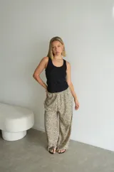 Pantalón ancho de tiro alto con elástico en la cintura y estampado animal print de leopardo en tonos beige y negro.
