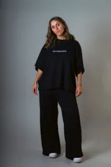 Conjunto negro de punto prato, compuesto por un top de mangas cortas con logo bordado y un pantalón palazzo de cintura elastizada.