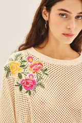 Sweater color crema de algodón con tejido calado y bordado de flores en el hombro.