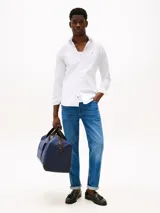 Camisa blanca de popelina con tecnología flex, corte slim, cuello con botones, cierre con botones, manga larga y logo de Tommy Hilfiger bordado en el pecho.