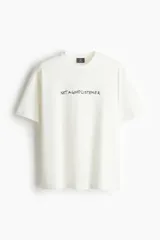 Remera blanca de corte holgado con cuello redondo y estampado con la frase "NOT A GOOD LISTENER" en letras negras.