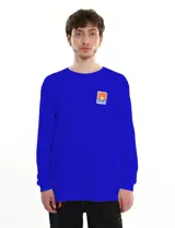 Remera azul de manga larga confeccionada en algodón, con parche cuadrado en el pecho con un diseño de un atardecer.