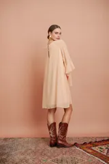 Vestido corto color salmón claro, de mangas largas con volados y corte suelto.