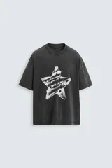Camiseta negra con efecto lavado, corte relaxed fit, cuello redondo y mangas cortas. Estampado frontal con una estrella y texto en color blanco.