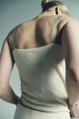 Top de punto color crema claro, corte recto y ajustado, con detalle de encaje floral bordado en el escote. Posee tirantes ajustables de color beige claro.