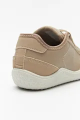Zapatillas de cuero color blanco y beige, de diseño minimalista con suela marrón.