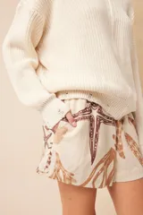 Short de lino color crudo con estampado de motivos marinos en tonos marrones.