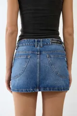 Minifalda de denim azul con tiro a la cadera, terminación recta y bolsillos funcionales.