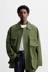 Parka verde militar de tejido técnico ligero, corte relaxed fit, cuello solapa y manga larga. Tiene cuatro bolsillos de plastrón con solapa en el delantero, cintura ajustable en el interior y cierre frontal con cremallera oculta por solapa con botones a presión.