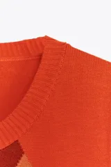 Top chaleco de punto color naranja con patrón de rombos en tonos naranja, blanco y marrón. Tiene cuello redondo y sisa.