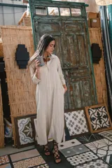 Camisa negra de manga larga con cuello camisero y cierre frontal con botones. Presenta detalles de ribete blanco en cuello, puños y abertura frontal.