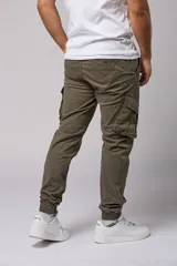 Pantalón cargo color beige de gabardina, con corte ajustado, bolsillos laterales con fuelle y puños elásticos en los tobillos.