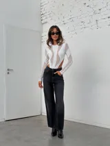 Body blanco de mangas largas con transparencias y recortes geométricos.