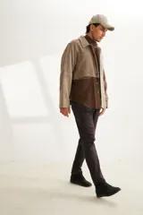 Camisa de hombre estilo leñadora con diseño patchwork en tonos beige y marrón. Presenta coderas, cartera americana y bolsillo ojal en el delantero. Confeccionada en lana fina sin teñir.