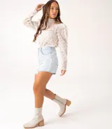 Bota corta color crema con textura de reptil, caña media, punta cuadrada, cierre lateral y taco de madera.