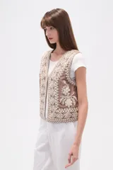 Chaleco sin mangas color marrón topo, con escote en V y bordados intrincados en color crema/blanco que cubren toda la prenda.