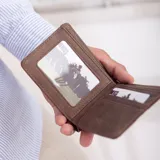Billetera negra de símil cuero con banda elástica horizontal blanca. Interior con doble compartimento para billetes, visor y tarjeteros.