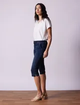 Pantalón capri blanco de algodón elastizado. Pretina con pasadores, botón y cierre. Delantera con bolsillos. Trasera con bolsillos simulados.