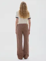 Jean wide leg color marrón con estampado de rombos en tonos beige y azul. Incluye un cinturón integrado en la pretina con hebilla metálica.