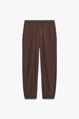 Pantalón bombacho color marrón confeccionado en algodón 100%. Tiro medio con cintura elástica ajustable con cordones y bajo abullonado con elástico.