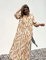 Vestido largo tipo túnica con estampado de cebra en tonos beige y crudo, con cuello en V y mangas 3/4.