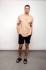 Remera beige con estampado de texto en el pecho.
